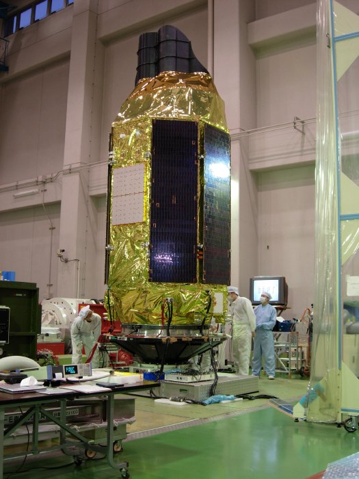 Astro-E2 is mounted to the speaker-shaped Z-axis shake table, as ISAS personnel look on (83K JPEG)