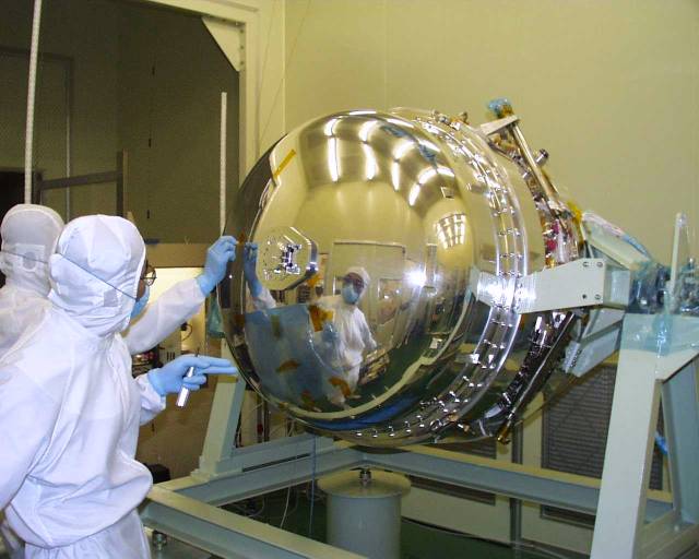 Silver-domed Dewar reflecting 2 bunny-suited engineers. (44K JPEG)