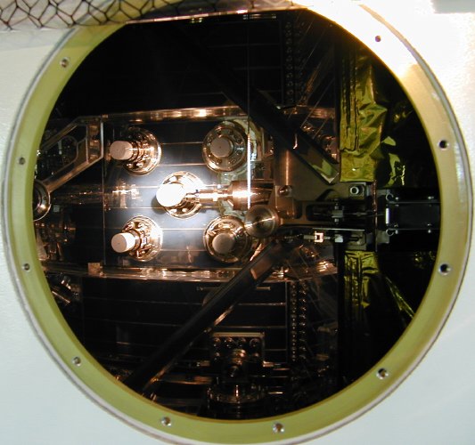 Five white plugs seen through a hole in the fairing (57K JPEG)